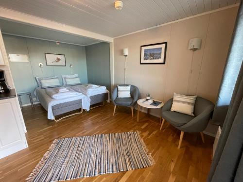 a room with two beds and a chair and a table at Lofoten Rorbuer in Svolvær