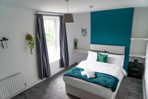 a bedroom with a bed with a blue accent wall at MMR Homes in Carlisle