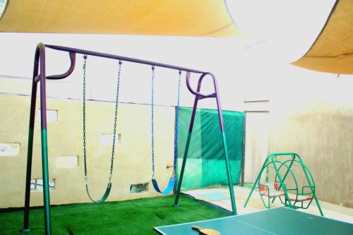 a playground with a swing set in a room at Celina's farm in Al Rama