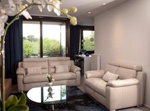 a living room with two couches and a table at Suite Aux Anges in Antwerp