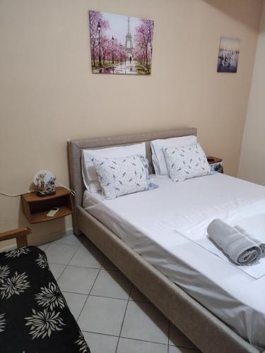 Bett mit weißer Bettwäsche und Kissen in einem Zimmer in der Unterkunft Villa Luna Vista in Sarandë