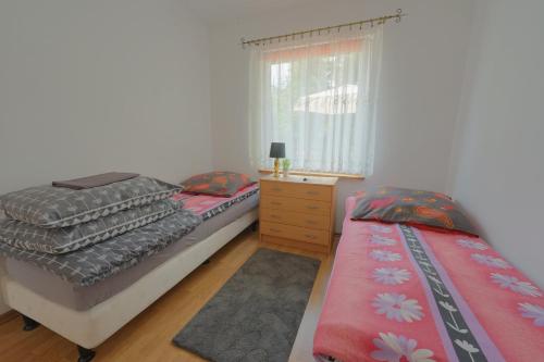 a bedroom with two beds and a dresser and a window at Domki Oliwia in Łeba