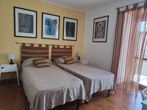 2 Betten in einem Hotelzimmer mit 2 Betten sidx sidx sidx sidx in der Unterkunft Casa Parco Aranci in Formia
