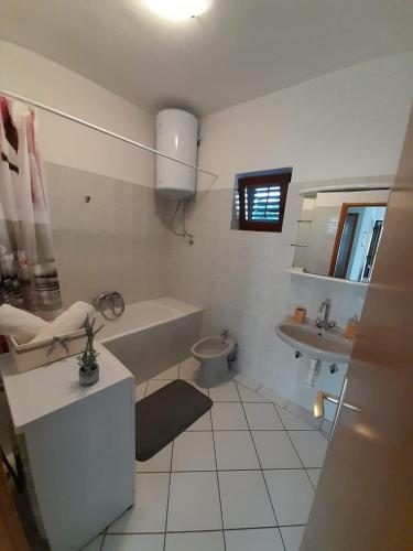 a bathroom with a tub and a toilet and a sink at Lucija in Pridraga