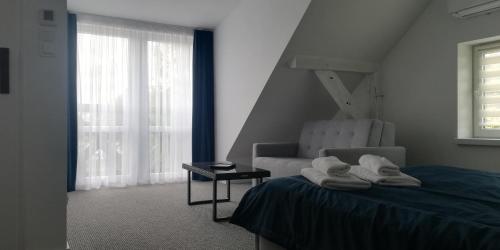sypialnia z łóżkiem, krzesłem i oknem w obiekcie Mazuria Inulec w mieście Mikołajki