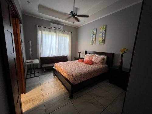 een slaapkamer met een bed en een plafondventilator bij Casa Famari at Playa Bejuco in Bejuco