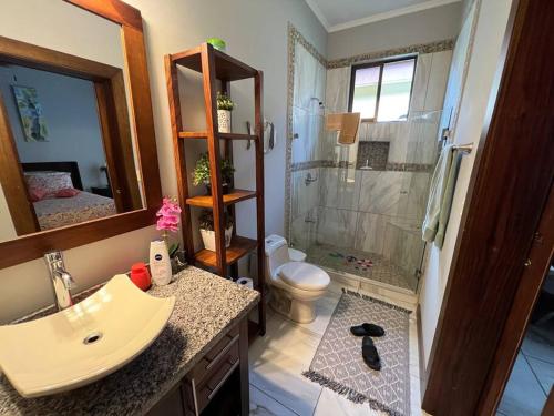 a bathroom with a sink and a shower and a toilet at Casa Famari at Playa Bejuco in Bejuco