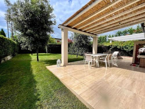 a patio with a table and chairs under a pergola at Villa Carli in centro a Forte dei Marmi in Forte dei Marmi
