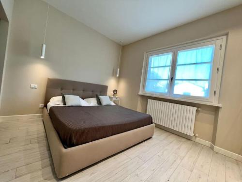 um quarto com uma cama e uma grande janela em Villa Carli in centro a Forte dei Marmi em Forte dei Marmi