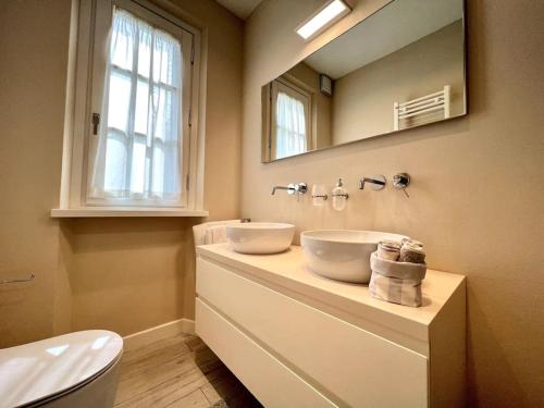 a bathroom with a sink and a mirror and a toilet at Villa Carli in centro a Forte dei Marmi in Forte dei Marmi