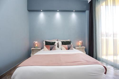 1 dormitorio con 1 cama grande y 2 lámparas en las mesas en By the Sea Apartments-studios, en Siviri