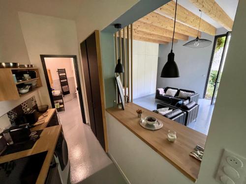 a kitchen with a counter and a living room at L’atelier d’Alain in Maxéville