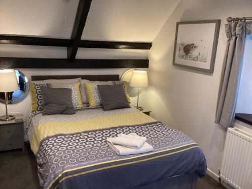 a bedroom with a bed with two towels on it at Y Bwythyn - Lovely cottage in village of Spittal in Haverfordwest