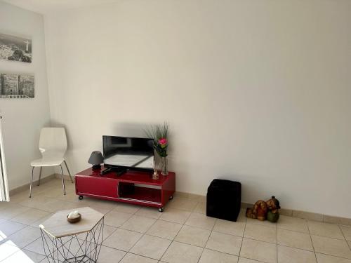 - un salon avec une télévision sur une armoire rouge dans l'établissement Studio climatisé cœur historique d'Ajaccio, à Ajaccio