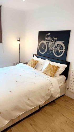 a bedroom with a bed with a picture of a bike on the wall at Tee SweetLux Apartment in London