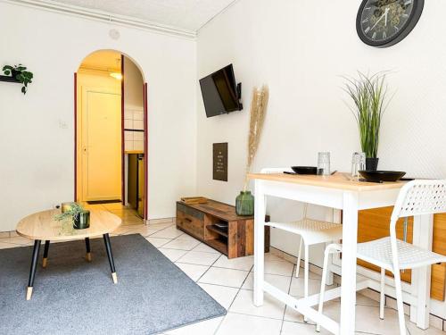 a living room with a table and a yellow door at NEW ! Le Coeur de ville avec terrasse! Parking in Guingamp