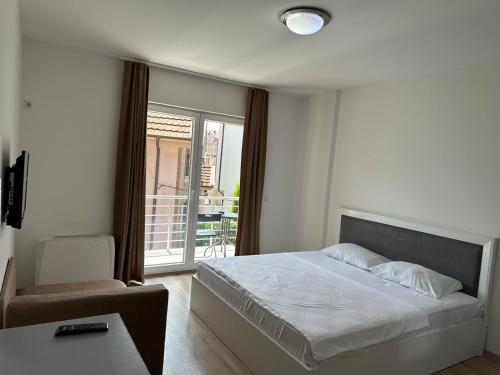 een slaapkamer met een bed en een groot raam bij Vila Andrra in Struga