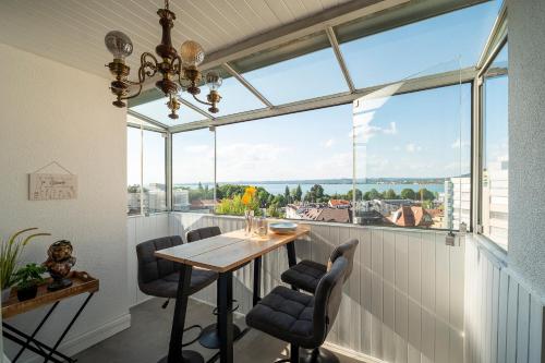 a dining room with a table and a large window at Seeblick Bregenz in Bregenz