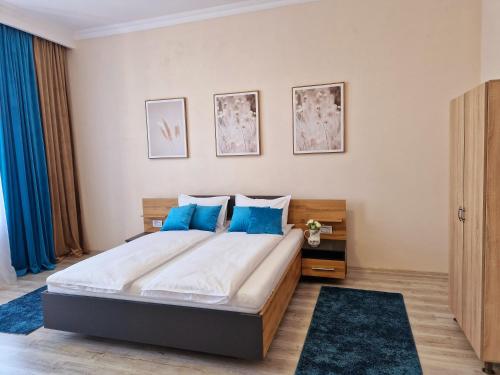 1 dormitorio con 1 cama grande con almohadas azules en ORI Classy Apart Malul Mureșului en Arad