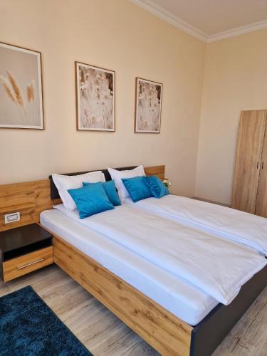 a bedroom with a large bed with blue pillows at ORI Classy Apart Malul Mureșului in Arad