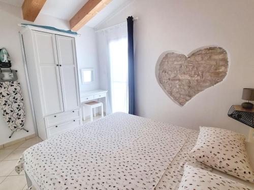 a bedroom with a bed and a heart on the wall at Stone House Mate in Rovinjsko Selo