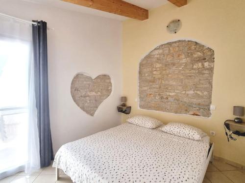 ein Schlafzimmer mit einem Bett mit einem Herz an der Wand in der Unterkunft Stone House Mate in Rovinjsko Selo