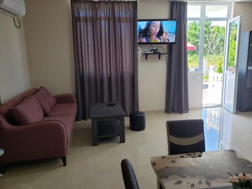 a living room with a couch and a flat screen tv at Villa MATE & Villa LUKA in Ureki