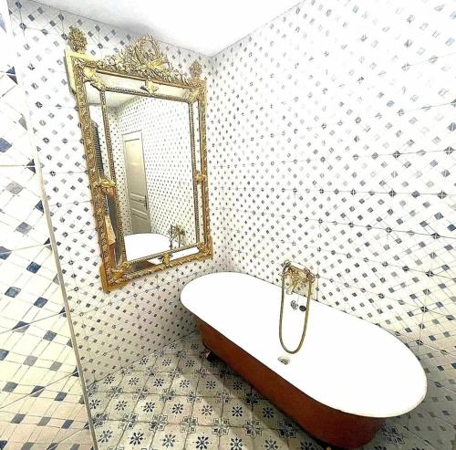 une salle de bain avec une baignoire et un miroir dans l'établissement Piano apartment, à Taurize