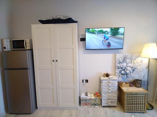 a room with a refrigerator and a tv on the wall at Apartments Tamara in Sukošan