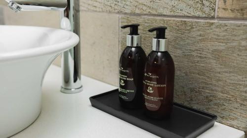 two bottles of soap on a black holder in a bathroom at The Lofts Luxury Suites in Windhoek