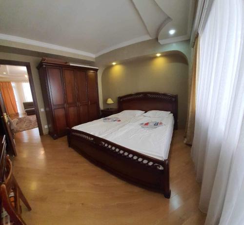 een slaapkamer met een groot bed met witte lakens bij appartments in Batumi in Batoemi