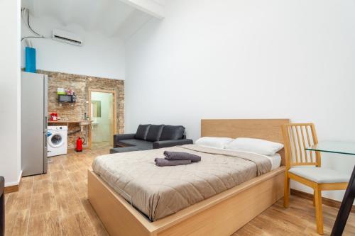 a bedroom with a bed and a living room at CAMP NOU & FiRA BUSINESS LOFTS in Barcelona