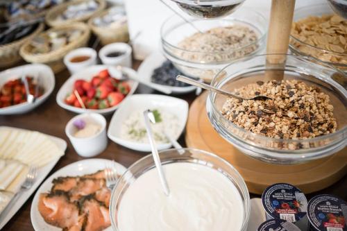 a table topped with bowls of food and other foods at Pension Haus Tirol in Laion