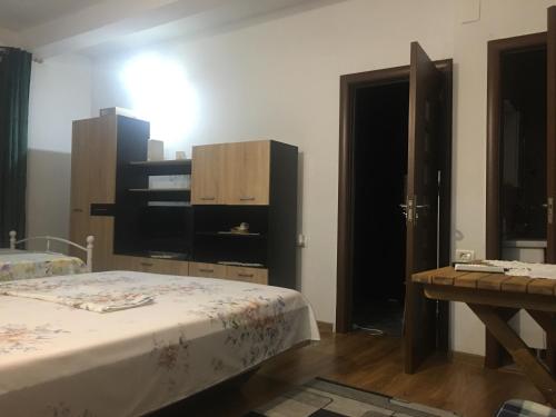 コンスタンツァにあるCazare la mare vila Constantaのベッドルーム1室(ベッド2台、テーブル、ドア付)