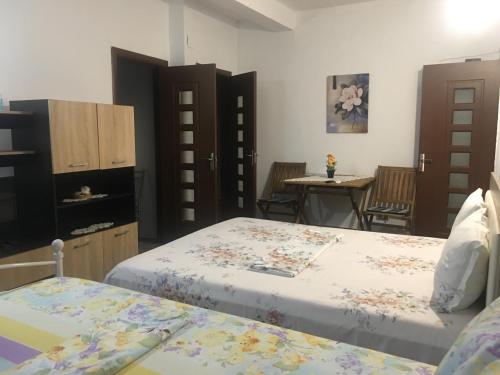 1 Schlafzimmer mit 2 Betten, einem Tisch und Stühlen in der Unterkunft Cazare la mare vila Constanta in Constanţa