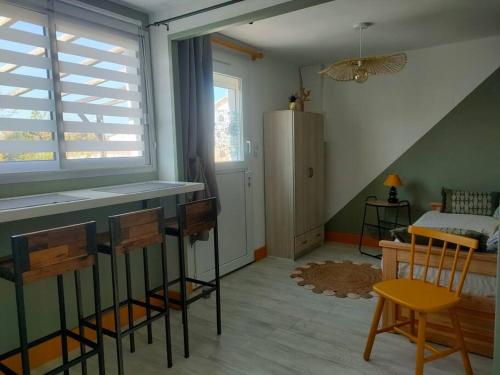 Cette chambre dispose d'une table, de chaises et d'un réfrigérateur. dans l'établissement Nid douillet climatisée avec terrasse et vélos, à Les Sables-dʼOlonne