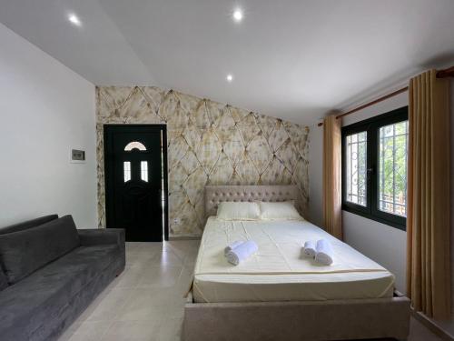 - une chambre avec un grand lit et un canapé dans l'établissement Hibroj Guesthouse, à Vlorë