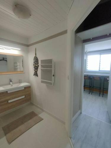 une cuisine blanche avec un évier et un comptoir dans l'établissement Nid douillet climatisée avec terrasse et vélos, à Les Sables-dʼOlonne