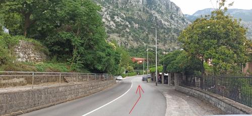 a road with a red arrow on the road at Java Apartments in Dobrota