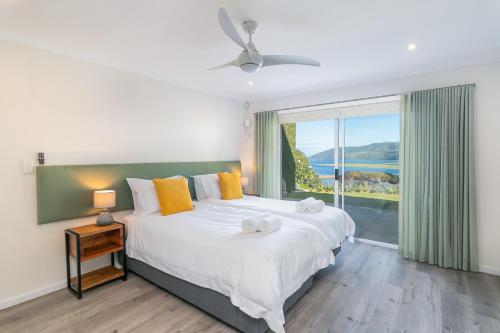 a bedroom with a large bed and a large window at Stunning Villa with pool and views of Knysna in Knysna