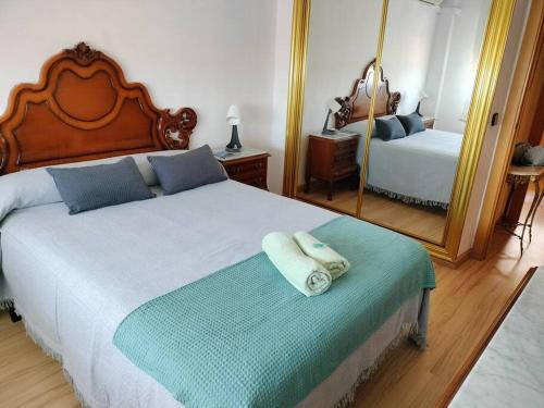 een slaapkamer met een groot bed en een spiegel bij Apartamento Deluxe El Camino in Alcalá de Henares