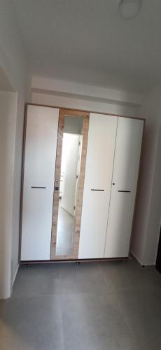 a room with two white cabinets and a mirror at Lux apartment 12 center, free parking in Niš