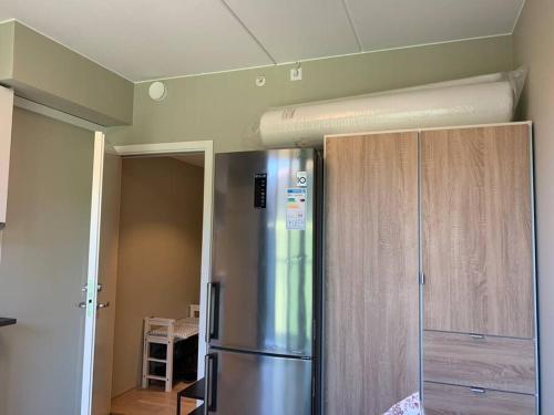 a kitchen with a stainless steel refrigerator and wooden cabinets at Central 1 bedroom apartment NB!! Small room in Oslo