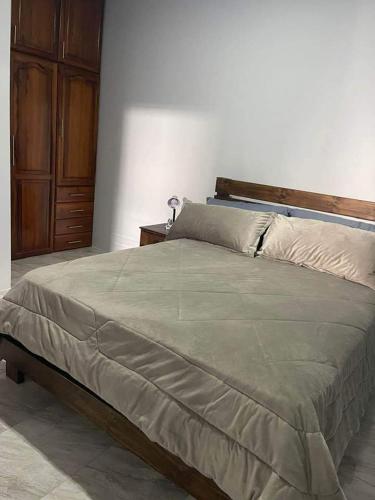 - une chambre avec un grand lit et une tête de lit en bois dans l'établissement Departamento vista al mar Puerto López, à Puerto López