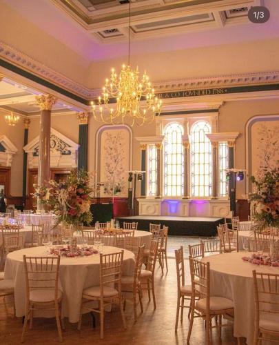 a banquet hall with tables and chairs and a chandelier at The Parr’s Bank Hotel in Warrington
