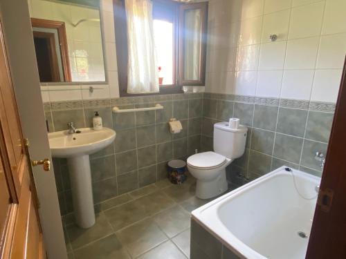 uma casa de banho com um WC, um lavatório e uma banheira em Acogedora casa en Onís - Cangas de Onis em Avín