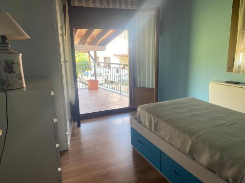 um quarto com uma cama e uma porta para uma varanda em Acogedora casa en Onís - Cangas de Onis em Avín