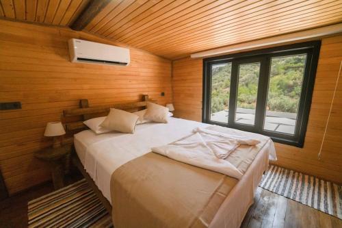 1 dormitorio con 1 cama en una habitación con ventana en Tiny Timber, en Kas