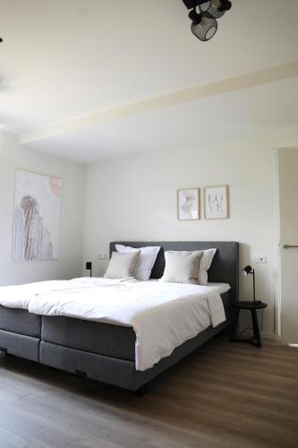 a bedroom with a large bed with white walls at Vakantiewoningen Liefst in Epen in Epen