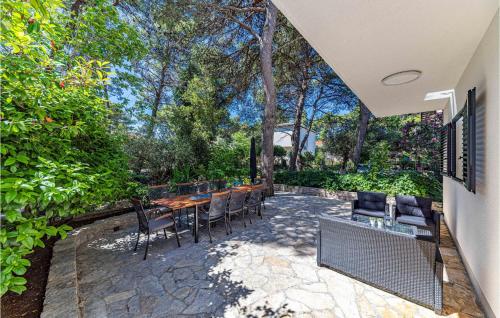 a patio with a table and chairs and trees at Holiday Home Jadrija Vii Iii in Jadrija